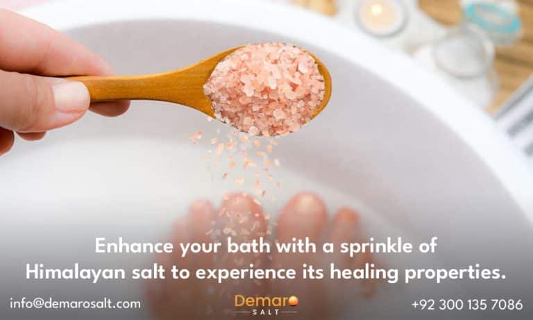 A person pouring a small amount of Himalayan salt into the bathwater.