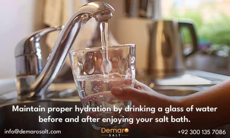 A person hydrating with a glass of water before a salt bath.